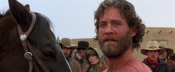 Movie still from “Silverado” (1985), directed by Lawrence Kasdan – A person with a horse in the background; Close Up shot, Low angle