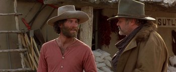 Movie still from “Silverado” (1985), directed by Lawrence Kasdan – Two men in cowboy hats talking to each other; Medium shot, Low angle