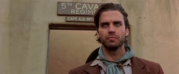 Movie still from “Silverado” (1985), directed by Lawrence Kasdan – A man standing in front of a building; Close Up shot, Low angle