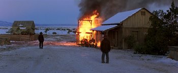 Movie still from “Silverado” (1985), directed by Lawrence Kasdan – A man standing in front of a burning house; Extreme Wide shot, Low angle