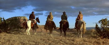 Movie still from “Silverado” (1985), directed by Lawrence Kasdan – A group of people riding horses in a field; Wide shot, Low angle