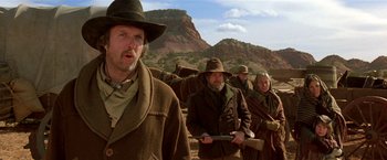 Movie still from “Silverado” (1985), directed by Lawrence Kasdan – A group of people in a field with a mountain in the background; Medium shot, Low angle