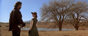 Movie still from “Silverado” (1985), directed by Lawrence Kasdan – A woman standing in front of a tree in a field; Wide shot, Low angle