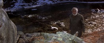 Movie still from “Silverado” (1985), directed by Lawrence Kasdan – An older man standing in front of a river; Wide shot, High angle