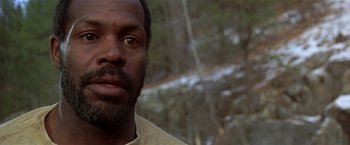 Movie still from “Silverado” (1985), directed by Lawrence Kasdan – A man's face in a wooded area; Close Up shot, Low angle