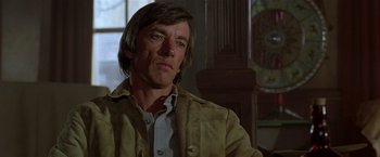 Movie still from “Silverado” (1985), directed by Lawrence Kasdan – A person sitting in a room; Close Up shot, Low angle