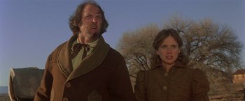 Movie still from “Silverado” (1985), directed by Lawrence Kasdan – A man and a woman standing next to each other in front of a tree; Medium shot, Low angle