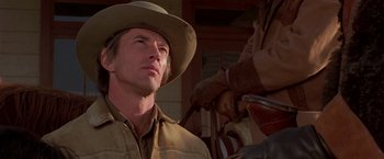 Movie still from “Silverado” (1985), directed by Lawrence Kasdan – A man wearing a cowboy hat looking at something; Close Up shot, Low angle