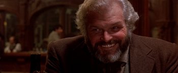 Movie still from “Silverado” (1985), directed by Lawrence Kasdan – An older man with a beard smiling for the camera; Close Up shot, Low angle