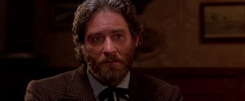 Movie still from “Silverado” (1985), directed by Lawrence Kasdan – A person wearing a suit and tie; Close Up shot, Low angle