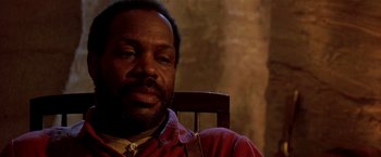 Movie still from “Silverado” (1985), directed by Lawrence Kasdan – A person sitting in a chair; Close Up shot, Low angle