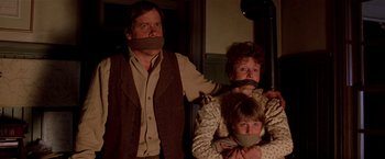 Movie still from “Silverado” (1985), directed by Lawrence Kasdan – A man and a woman and a child with their mouths taped shut; Close Up shot, Low angle