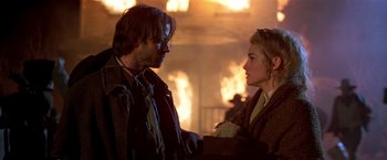 Movie still from “Silverado” (1985), directed by Lawrence Kasdan – A man and a woman standing next to each other in front of a fire; Close Up shot, Over the shoulder angle
