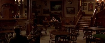 Movie still from “Silverado” (1985), directed by Lawrence Kasdan – People sitting at tables in an old western style restaurant; Wide shot, High angle