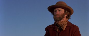 Movie still from “Silverado” (1985), directed by Lawrence Kasdan – A man with a beard wearing a brown hat; Close Up shot, Low angle
