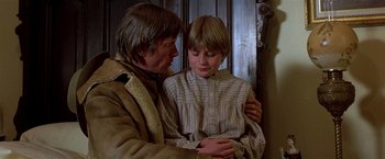Movie still from “Silverado” (1985), directed by Lawrence Kasdan – A man and a young boy are standing next to each other; Medium shot, Over the shoulder angle