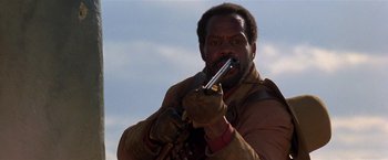 Movie still from “Silverado” (1985), directed by Lawrence Kasdan – A man holding a knife in his mouth; Close Up shot, Low angle