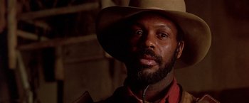 Movie still from “Silverado” (1985), directed by Lawrence Kasdan – A person wearing a cowboy hat; Close Up shot, Low angle