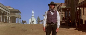 Movie still from “Silverado” (1985), directed by Lawrence Kasdan – A man standing in front of an old church; Wide shot, Low angle