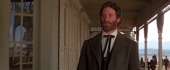 Movie still from “Silverado” (1985), directed by Lawrence Kasdan – A man with a long beard wearing a suit and tie; Close Up shot, Low angle