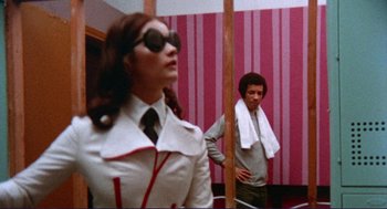 Movie still from “Sisters” (1972), directed by Brian De Palma – A man and a woman are standing in front of a mirror; Medium shot, Low angle