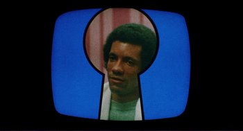 Movie still from “Sisters” (1972), directed by Brian De Palma – A man's face through a peephole; Extreme Close Up shot, High angle