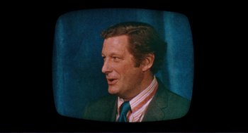 Movie still from “Sisters” (1972), directed by Brian De Palma – A person wearing a suit and tie; Close Up shot, High angle