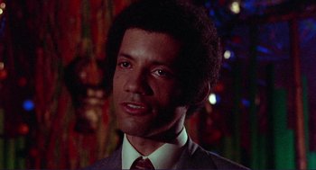 Movie still from “Sisters” (1972), directed by Brian De Palma – A person wearing a suit and tie; Close Up shot, Low angle