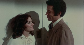 Movie still from “Sisters” (1972), directed by Brian De Palma – A man and a woman standing next to each other; Medium shot, High angle