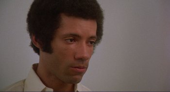 Movie still from “Sisters” (1972), directed by Brian De Palma – A person wearing a white shirt; Close Up shot, Low angle