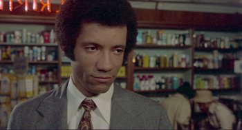 Movie still from “Sisters” (1972), directed by Brian De Palma – A person wearing a suit and tie; Close Up shot, Low angle