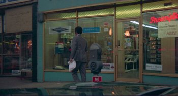 Movie still from “Sisters” (1972), directed by Brian De Palma – A man walking down the street in front of a store; Wide shot, Low angle
