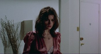 Movie still from “Sisters” (1972), directed by Brian De Palma – A woman with long hair wearing a pink dress; Medium shot, High angle