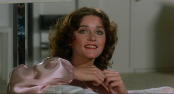 Movie still from “Sisters” (1972), directed by Brian De Palma – A person with curly hair wearing a pink shirt; Close Up shot, Low angle