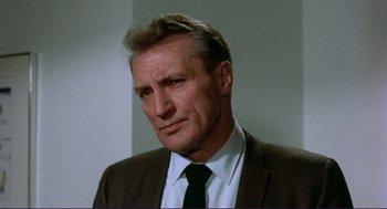 Movie still from “Sisters” (1972), directed by Brian De Palma – A man in a suit and tie looking at the camera; Close Up shot, Low angle