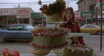 Movie still from “Sisters” (1972), directed by Brian De Palma – A woman standing in front of a cake on a table; Wide shot, Over the shoulder angle