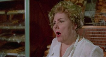 Movie still from “Sisters” (1972), directed by Brian De Palma – An older woman with curly blonde hair is looking surprised; Close Up shot, Low angle