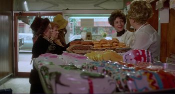Movie still from “Sisters” (1972), directed by Brian De Palma – A group of women sitting at a table with donuts on it; Medium shot, Over the shoulder angle