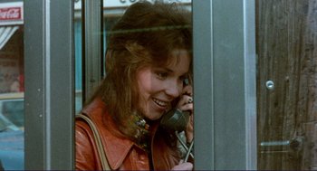 Movie still from “Sisters” (1972), directed by Brian De Palma – A woman talking on a phone while wearing a red leather jacket; Close Up shot, Over the shoulder angle