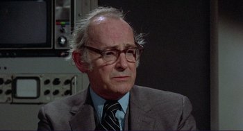 Movie still from “Sisters” (1972), directed by Brian De Palma – An older man wearing glasses and a suit; Close Up shot, Over the shoulder angle