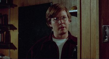 Movie still from “Sisters” (1972), directed by Brian De Palma – A man with glasses is standing in front of a mirror; Close Up shot, Over the shoulder angle