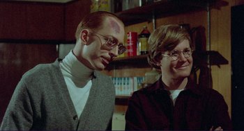 Movie still from “Sisters” (1972), directed by Brian De Palma – A man and a woman sitting next to each other in a room; Medium shot, Over the shoulder angle