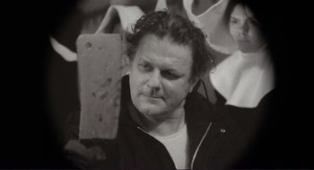 Movie still from “Sisters” (1972), directed by Brian De Palma – Black and white photograph of a man in a black jacket; Close Up shot, Low angle