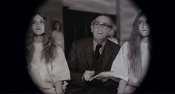 Movie still from “Sisters” (1972), directed by Brian De Palma – An older man sitting next to two young women; Medium shot, Over the shoulder angle