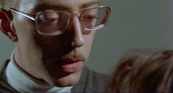 Movie still from “Sisters” (1972), directed by Brian De Palma – A person wearing glasses; Close Up shot, Low angle
