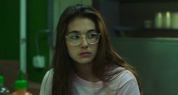 Movie still from “Skate Kitchen” (2018), directed by Crystal Moselle – A woman with glasses is sitting in a room; Close Up shot, Over the shoulder angle