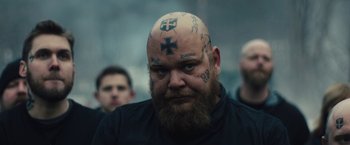 Movie still from “Skin” (2018), directed by Guy Nattiv – A man with tattoos on his head is looking at the camera; Close Up shot, Over the shoulder angle