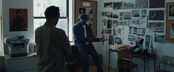 Movie still from “Skin” (2018), directed by Guy Nattiv – A man sitting on a chair in front of a wall; Medium shot, Over the shoulder angle