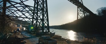 Movie still from “Skin” (2018), directed by Guy Nattiv – A truck parked on the side of a river near a bridge; Extreme Wide shot, Low angle