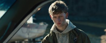 Movie still from “Skin” (2018), directed by Guy Nattiv – A young man in a hooded jacket looking at the camera; Close Up shot, Over the shoulder angle